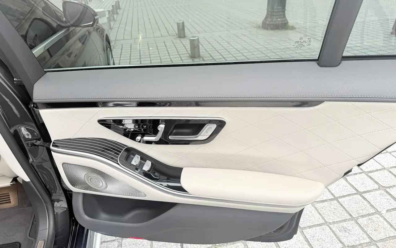 Open rear door of a Mercedes S-Class, ivory door panel, Place Vendôme through the window