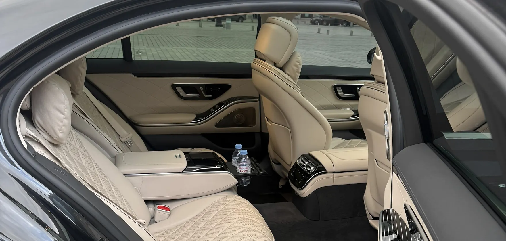 Open rear door of a Mercedes S-Class and its ivory rear cabin on Place Vendôme